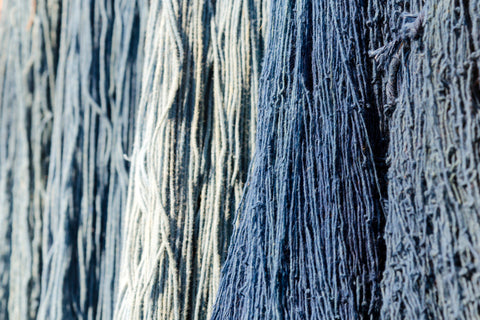 organic cotton yarn dyed with herbal dyes hangs from above